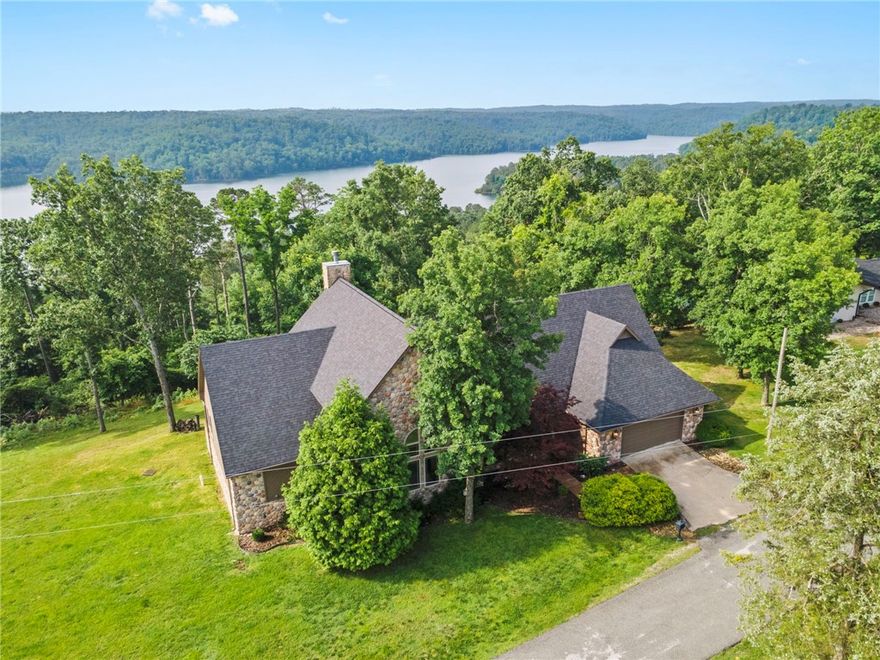 Expansive lake views of Beaver Lake's Van Hollow from this well built, well maintained, 1-owner home! House sits on a double lot for 1.29 acres & includes an extra, buildable lot of .67 acres (guest house? workshop? sell? keep?) totaling ~2 acres of land. Lake view can be enhanced further w/more clearing! Neat floorplan w/5 bedrooms, 3 baths, multiple living areas, sunroom/office, dining room & huge 4-car-tandem-style garage. Entertain in the great room w/soaring ceilings & gas fireplace accented w/river rock or step outside & enjoy the spacious deck. New impact resistant roof ('24), newer HVAC systems (2), whole house generator, quartz counters! Currently on well water but rural water at the street (tap fee ~$3000.) Solid wood finishes throughout the home exude the feel of a true Ozark mountain lodge. Travel a short 2-miles to Rocky Branch Marina for boat launch & slip rentals or 3-miles to the Shaddox Hollow Trail & Hobbs State Park access. Come be impressed! (Listed w/out extra lot for $795,000 as MLS #1308775.)