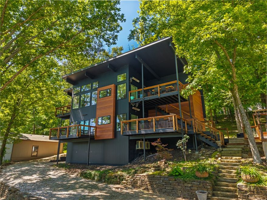 $10k Buyer Credit Rare Beaver Lake investment opportunity offering multiple income-producing setups, flexible use options, and included boat slip access. This architecturally striking property is currently configured for 3 rental opportunities and includes a 2,500 SF main home with separate entrances and full kitchens on both levels, allowing the spaces to function independently for short-term rental income, vacation use, or multi-generational living. A detached and updated guest cottage creates an additional income-producing setup or guest space. The property features soaring ceilings, expansive windows, warm wood accents, stone fireplace, multiple outdoor entertaining decks, detached garage/game space, and wooded lake surroundings that appeal to vacation rental guests. Included is a private 10' x 24' boat slip with lift, swim platform within a nearby 2-owner community dock, nearby. Existing STR history with upside potential depending on owner usage and management strategy. Also listed residential, MLS 1347188