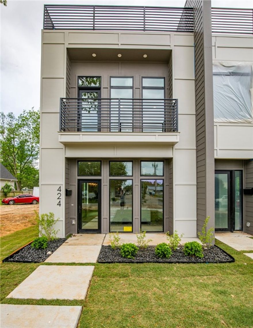 Welcome to a collaborative effort with a local architect/design team that will blow you away. This townhome has a sleek contemporary design and is located, fittingly, in the heart of the music and art district in downtown Bentonville, just steps away from the Momentary. Every detail has been lovingly curated by the architect/design team with great attention to detail - Striking mixed metals, large casement windows allowing light throughout, glass stairwell, and marvelous lighting hand picked by the designer.  The main house is comprised of 3 levels and has the flexibility of 3 bedrooms (2 primary bedrooms with en-suite bathrooms) or 2 bedrooms and a 3rd floor bonus room. On the third floor is a rooftop terrace overlooking downtown Bentonville. A privacy fence separates the townhomes and a detached 2 car garage is to the back of the property. Above the garage is a 400 SF studio apartment with the same impeccable design as the main house. This can serve as a guest suite or an income producing property.