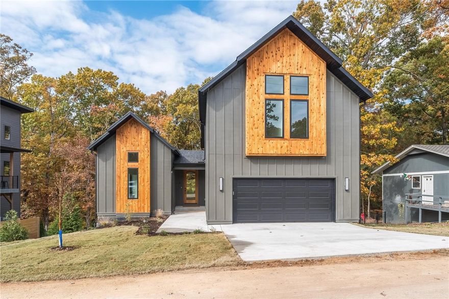 This modern contemporary home has high-end finishes with a very comfortable layout.  Walk in to 20' ceiling and floor to ceiling windows that let in the beauty of the treed backyard and deck.  The large living room has a fireplace to enjoy and easy to entertain layout.  The unique kitchen features quartz counters and designer tile backsplash,built in microwave and a full extra counter for coffee bar or prep work.Brass lighting over the island rounds out look.  The built in cabinets along the side are a surprise addition.The master suite on the main level connects to a spa-like bath with dual sinks,custom shower and soaking tub. The roomy closet features a nice window for extra light.There is also a half bath on main level for convenience.  Laundry room and pantry are next to the garage entry.  The 2nd floor has 3 bedrooms and a full bath with dual sinks.  There is a large bonus area for office or playroom.    The 23x10 deck will be a great hangout place to enjoy nature. The garage floor has an epoxy finish added.