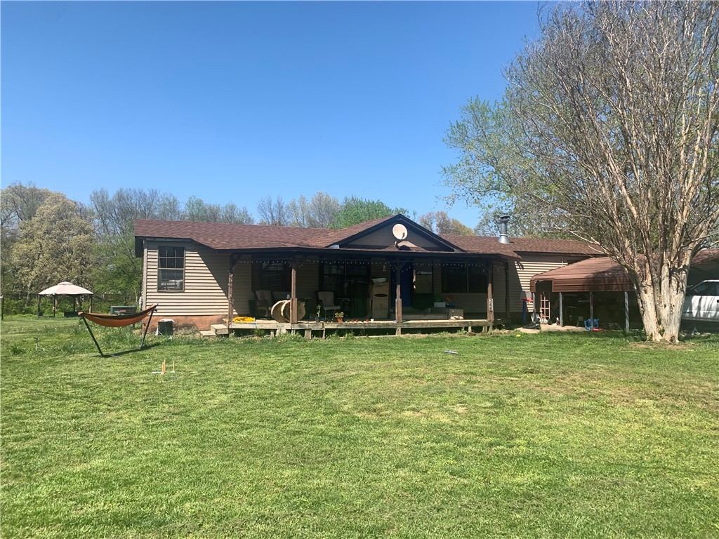 Don't miss out on this opportunity! Double-Wide mobile home sitting on block & anchor system and flat 1.22 acres. Huge living area with wood burning fireplace, spacious kitchen with plenty of cabinets and stainless steel gas range. Large dining area, large bedrooms, large master bath, so much room! New roof March of 2020, AC about 6 years old, newer flooring, some new light fixtures. Two car carport and 16x12 storage conveys. Currently owner occupied. Sellers performed some cosmetic renovations but were not able to finish, sold "AS IS" and price reflects as such. Put your finishing touches and call it your home!