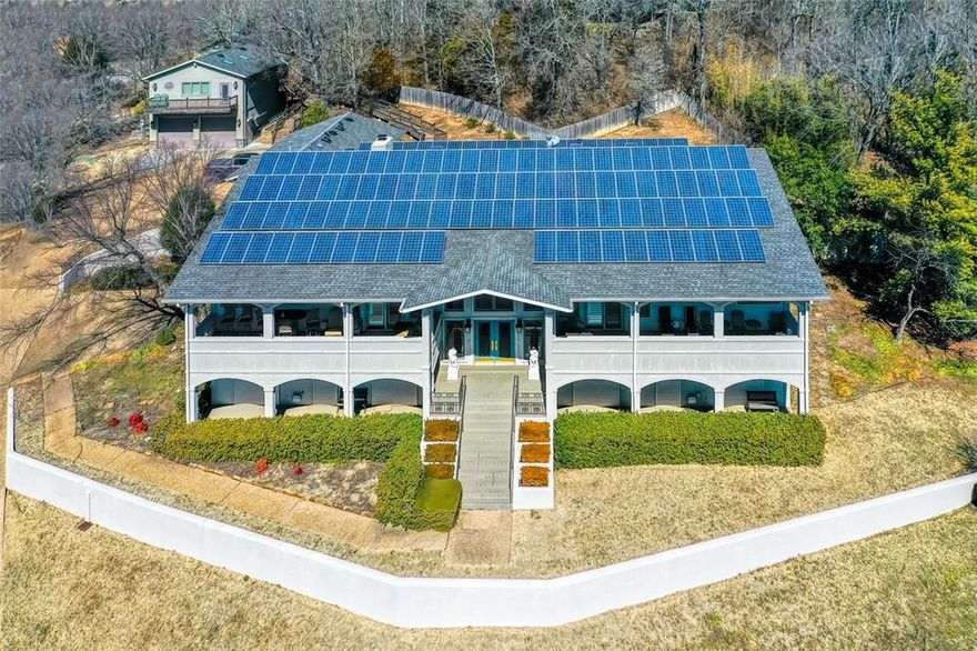 A fortress in Fayetteville. The over 7500 sq. ft. home plus garage/workshop/office/flex space (2464 sq. ft.) both sit on 3 large lots with 1.19 acres total. Amazing views. Home is nearly self sufficient with a solar panel system, city and well water, and upgraded security features. Main level features a gourmet kitchen, breakfast area, formal dining, living room with wet bar, sunroom and many built-ins. Primary bedroom has fireplace, laundry, and a bathroom with walk in shower and air jetted tub. Take the elevator from the main level to the walkout basement. You will find 3 more bedrooms (one could be a 2nd primary), game room, wet bar, office, wine cellar, multiple storage rooms, a 2nd laundry, and one of the most impressive theaters you will ever see in a home. 3 car attached garage. Detached garage with space for 2 cars on main level. 2nd level can be reached by another elevator and contains an office, bathroom, and a huge flexible room. See attachment for amenities. (Total beds/baths include both buildings).