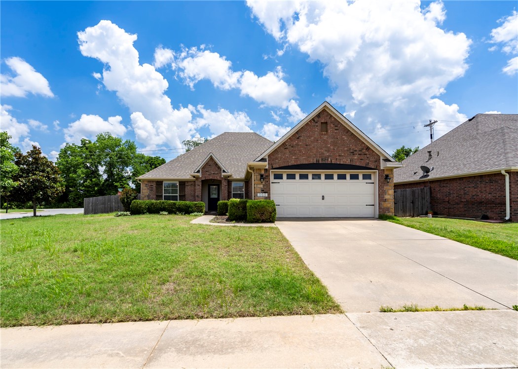 Welcome to this charming 3BD, 2BA, 1810SF all-brick home situated on a desirable corner lot! This split floorplan offers hardwood flooring in the living room & primary bedroom, tile in the main areas, and carpet in the guest bedrooms. One of the bedrooms has a built in desk. Eat in kitchen has granite countertops, SS appliances, center island & pantry. Gather around the gas log fireplace in the living room for cozy evenings at home. The primary bedroom has a tray ceiling, a large walk-in closet, primary bath has dual vanities, shower & a whirlpool tub to relax in. Enjoy the fully landscaped front yard, or step out back to the concrete patio, wood deck & built in pergola—ideal for entertaining. The fully fenced backyard adds both privacy & peace of mind. Conveniently located near I-49, just minutes from U of A campus & close to parks, schools & trails!
