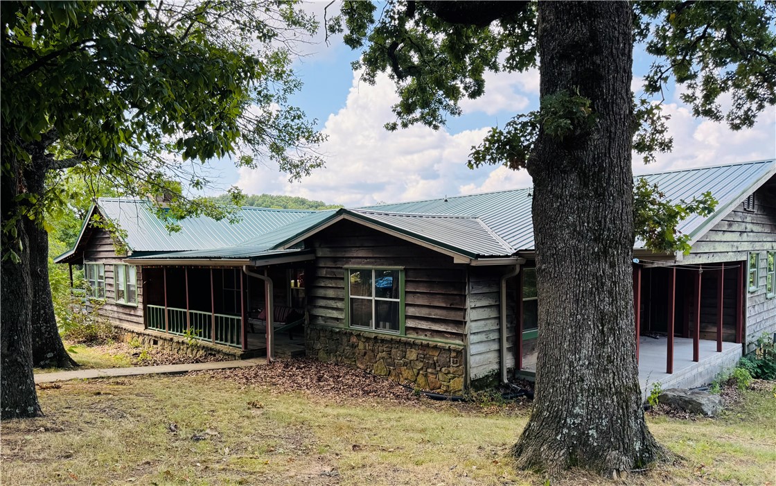 Bring the family and your business plan—Centerpoint Lodge delivers both. Ideally set at Hwy 43 & Fire Tower Rd, directly across from the Centerpoint Trailhead, this 1976 lodge blends comfortable owner living with multiple income streams. On the main level, the owner’s quarters feature a large kitchen, dining area, rock fireplace, and a wraparound porch. The walkout basement offers two spacious guest suites, each with queen beds, kitchens, and full baths. Additional lodging includes hostel-style rooms with shared baths, private suites, and a separate cabin/bunkhouse that sleeps 6–8 with its own kitchen and bath. Outside, guests enjoy RV hookups (water/sewer), a shower house, and horse pens for trail riders. Already a hub for side-by-side/ATV rentals, the property attracts hikers, paddlers, and families exploring Newton County’s waterfalls, bluffs, and the Buffalo National River. A rare chance to live where you work—residence, retreat, and revenue in one Ozark location. Listed as commercial listing MLS#1318503