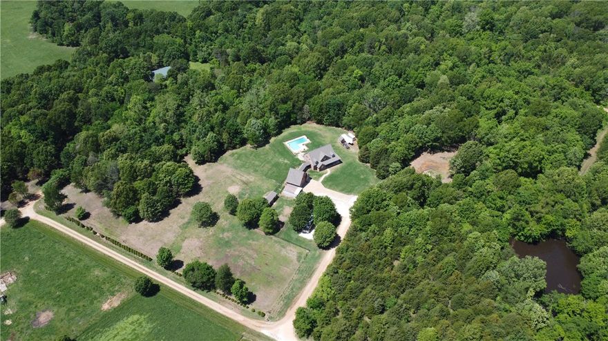 Gracious Southern home on 11 acres of land beckoning you to come unwind from the moment you step onto the front walkway with recessed lighting and climb the steps to the wrap around front porch and take it all in-- the pastoral views, large pool, quaint horse barn, and two-story fireplace in the living room.  This classic home has many upgraded features including a Jen-Air stove, custom kitchen pantry, central vac in the house and garage, dedicated office space with built-in shelving, bonus area above the garage and a 12 x 24ft storage building.  Pool pump, pellet stove, and jetted tub motor all new in 2023!

Adjacent 14 acres for sale.  See ml #1275614