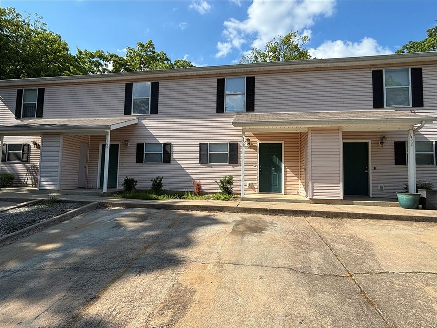 Two-story rental property located at 1368 S Sequoyah Way in Fayetteville, AR, offering 2 bedrooms and 1.5 baths. The unit includes a full appliance package with stove, dishwasher, refrigerator, washer, and electric dryer. Conveniently located near shopping, dining, and local amenities with a functional two-level layout.
