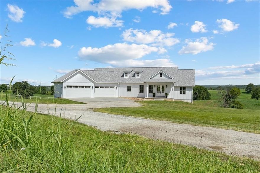Where modern luxury meets country living—complete with stunning sunset and rolling hill views and over 4,000 sq. ft. of beautifully designed space. Custom built in 2019, this 5-bedroom, 4-bath home is packed with premium features, including white oak hardwood floors, Andersen windows, composite decking, 18-inch floor joists, a commercial-grade tankless water heater, and 3 HVAC zones for year-round comfort.  The primary suite offers a private walkout to the expansive 10x50 foot back deck, heated tile floors in the ensuite bath, and an oversized walk-in closet that connects directly to the laundry room for ultimate convenience. The kitchen is nothing short of a dream—boasting a 10-foot island, custom cabinetry, quartz countertops, sleek tile backsplash and a walk-in pantry.  Crafted with exceptional detail and designed for both everyday living and entertaining, this home truly has it all!!