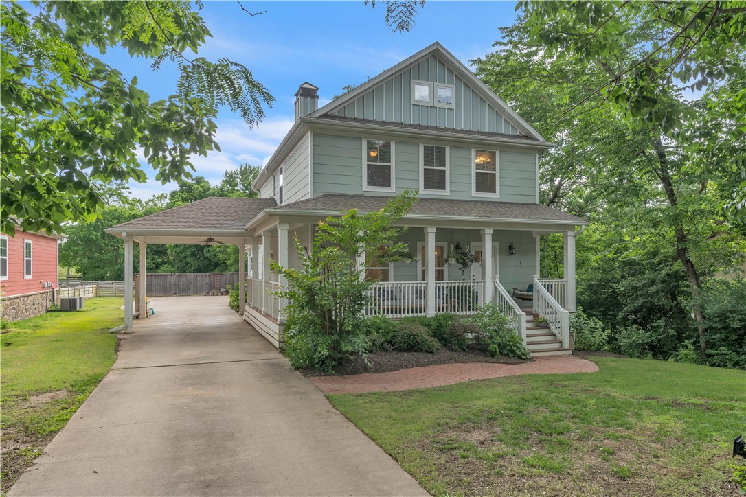 Location, location, location is what they say in real estate and solar power to boot! Located in East Fayetteville off Mission Blvd and walking distance to Root Elementary and close to Gulley Park. The fun begins on the covered front porch where you can sip tea and swing on the porch swing. Open your new front door and you're greeted by wood floors and a wide open living room with fireplace and built-in that leads to the open concept kitchen with white cabinets, stainless appliances and island with sink and dining area. Large primary bedroom is on main floor and features an ensuite with dual vanities and his/her walk-in-closets. A guest bathroom and laundry room finish out this floor. Upstairs you will find three more generous bedrooms. Bedroom 2 features an ensuite while bedrooms 3 and 4 share a Jack and Jill bathroom. Outside on the half acre +/- fenced lot you will find plenty of room to play with the kids and dogs. Covered carport and 2 car garage for parking. Solar panels help knock out the electric bill too.