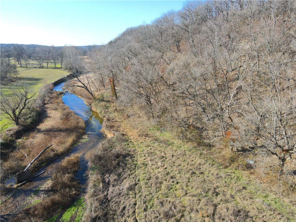 Imagine your very own acreage with a year-round, swimming hole quality creek, woods full of wildlife, and trails for exploring, under a 1/2 hour from the office on a Friday afternoon. Not just any creek, but the acclaimed Spavinaw Creek, known for its cool, spring fed water. This property includes flat, open hayfields along the banks of the creek, and more hilltop fields with scenic views. A large gravel bar provides the perfect recreational spot for campfires, sunbathing, swimming, arrowhead hunting, and more. ATV trails connect the upper and lower fields, and the gravel bar is accessible with a full size pickup. So many great features are packed into one tract, including fields, flowing water, mature hardwood trees, aesthetic rock bluffs, perennial spring, great hunting, and more. As NWA continues to grow, so will the demand for creek front property, especially when it is this convenient to town. Call today to arrange a private tour, and see for yourself all that this incredible property has to offer.