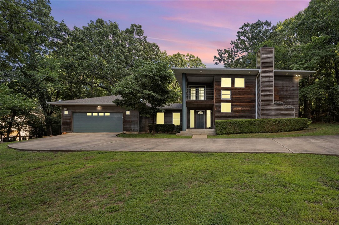 This expertly designed 3-bedroom, 3-bath home sits on a beautiful and private one-acre lot directly along the newly paved section of the Razorback Greenway Trail on Mission Boulevard, just 0.3 miles from Root Elementary. It was custom built as the personal residence of architect Hun Bae Im, an associate of James Lambeth and part of a distinguished architectural lineage tracing back to E. Fay Jones, a protƩgƩ of Frank Lloyd Wright. The home reflects hallmarks of this design heritage, including organic integration with the landscape and subtle nods to Prairie and Ozark Modern styles. The stained glass accent in the kitchen ceiling was sourced from a reputable antique shop in 1976 as a piece of Frank Lloyd Wright's work that was savaged from a building in Chicago! Recent updates since 2023 include a new roof, HVAC system, water heater, and an invisible pet fence. The interior was freshly repainted in fall 2024. Come see this special piece of Fayetteville architecture in one of the most sought-after locations!