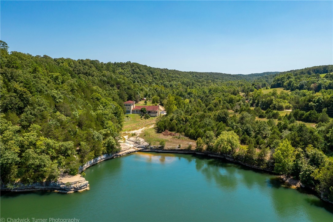 Seller called and is ready to move on. Huge price reduction of $500,000... Once in a lifetime opportunity to own this gorgeous lakefront estate at Hogscald Hollow on Beaver Lake. 3 separate land parcels with 900 ft of lake frontage and 3 coveted boat slips. Privacy is an understatement and the views are jaw dropping. Lots of great building sites gorgeous lake views. The home has soaring ceilings with gorgeous, exposed beams, stain glass windows, amazing hand-carved woodworking, inlayed wood flooring, Giant living spaces and covered patios with Million dollar views of Beaver Lake and the surroundings. This would make the ultimate corporate retreat/resort or vacation destination. Also see Matterport tour for full house tour. New survey dated 4-2022 attached