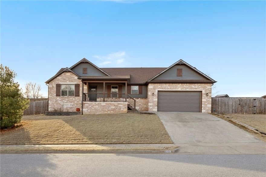 Welcome to a well-appointed 4-bedroom, 2-bath home offering comfortable living with thoughtful details throughout. The spacious kitchen features granite countertops, ample cabinet storage, generous prep space, and a dedicated coffee bar area. A brick accent detail carries seamlessly from the kitchen into the living room, complementing the cozy gas fireplace and creating a cohesive, inviting atmosphere. Vaulted ceilings with a wood beam accent add warmth and character to the large main living space. The primary suite provides a private retreat with dual sinks, a jetted tub, walk-in shower, and a large walk-in closet complete with built-in shelving in the en-suite bathroom. Three additional bedrooms offer flexibility for guests, family, or a home office. Outside, a fenced backyard with a covered deck is ideal for relaxing or entertaining, while a wooded area behind the fence provides added privacy. This charming home offers an inviting setting in a growing Northwest Arkansas community.