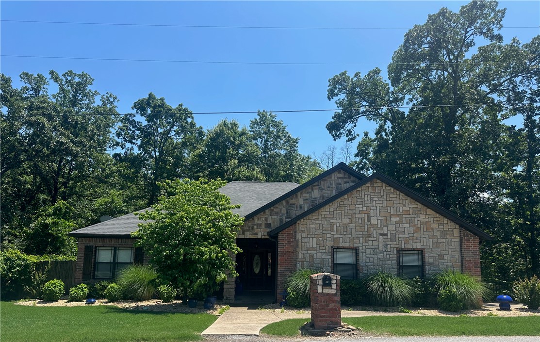 Nestled on the scenic Grandshire Drive loop, just minutes from the Metfield Rec Center, this beautifully maintained stone and brick home offers comfort, charm, and convenience. Step inside to an inviting open-concept living area featuring cathedral ceilings, a cozy fireplace, and gleaming wood floors. The spacious kitchen includes a pantry, a breakfast nook, and a versatile bonus space perfect for formal dining or a home office. With three generously sized bedrooms and two full bathrooms—including a recently upgraded primary suite shower—this home is both functional and stylish. Relax or entertain on the covered back porch surrounded by mature trees and natural privacy. Seller also installed Everlights so you can be festive all year round!