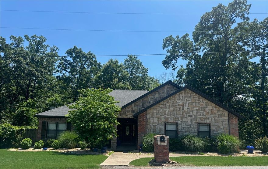 Nestled on the scenic Grandshire Drive loop, just minutes from the Metfield Rec Center, this beautifully maintained stone and brick home offers comfort, charm, and convenience. Step inside to an inviting open-concept living area featuring cathedral ceilings, a cozy fireplace, and gleaming wood floors. The spacious kitchen includes a pantry, a breakfast nook, and a versatile bonus space perfect for formal dining or a home office. With three generously sized bedrooms and two full bathrooms—including a recently upgraded primary suite shower—this home is both functional and stylish. Relax or entertain on the covered back porch surrounded by mature trees and natural privacy. Seller also installed Everlights so you can be festive all year round!