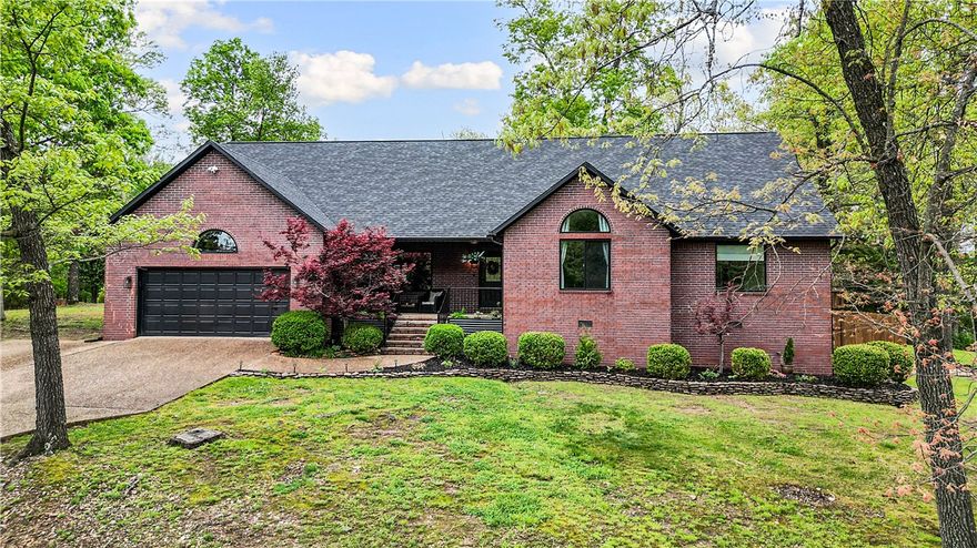 Beautifully updated, move-in ready 3BR home on a rare flat 0.66-acre lot in the heart of Bella Vista, offering comfort, privacy, and income potential. Ideally located near Oz Trails Bike Park and Blowing Springs trails. Surrounded by mature trees, this all-brick home features multiple porches and patios, creating inviting outdoor living spaces and abundant natural light throughout. Expansive foyer opens to hardwood floors and a spacious living room with cathedral ceilings, modern electric fireplace, and patio access—perfect for relaxing or entertaining. Updated kitchen offers ample storage, wine/coffee bar, and oversized pantry with barn door. Primary suite features a newly renovated luxurious en suite, large bedroom, and dual walk-in closets. Secondary bedrooms each include private en suite bathrooms and walk-in closets. Major updates: roof & A/C (Dec 2023), water heaters (Apr 2023), and front windows (Apr 2026). Back bedroom with private entrance ideal for STR income, guest suite, or private office.