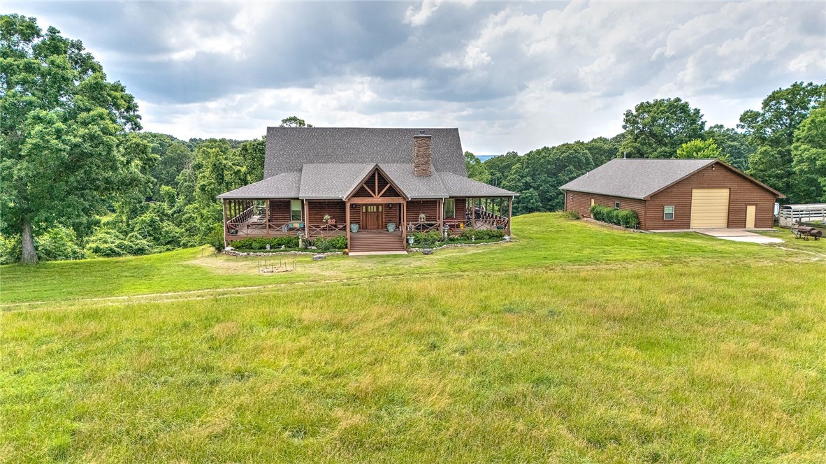 Dream Log Home! This outstanding masterpiece has full log walls, soaring ceilings, Custom Light fixtures, large fireplace, open living area and library loft, Bright fully equipped Kitchen, duel pantries, gas 6 burner Jen-Air cook top, prep sink, pot filler, farm sink, wired for ice machine, Full Fridge and full freezer, stunning Laundry!!! 1st level Main bedroom suite! upper level has 2 beds, 1 bath and a loft, basement has 2nd living room, large 4th bedroom/ craft room and bath with locked cedar lined closet. also, 635 sq ft unfinished storage/equipment room. Now for the 2nd best part!!!!! 40'x60' log sided shop w/ Kitchen, half bath and wood stove! All Roofs replaced 2023 plus, logs and wrap-a-round 10' porch re-stained in 2023. The land features hay fields, woods, and Corps of Engineers Beaver Lake frontage at the back of property.