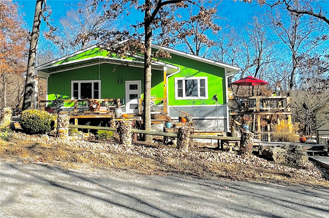 Built in 2021, get ready to walk into beauty all around! Located on quiet cul-de-sac. Professionally landscaped all around property. Fenced-in side yard gives opportunity for gardening, along with a large front porch and unique platform steps to the road. Flower gardens in front, raised vegetable gardens in back. Two water meters, one for household use and one for garden irrigation. New leaf-guard gutters. Recently graded side driveway and yard, carport ready. Luxurious vinyl flooring throughout the home. Very open kitchen including movable island, custom cabinetry, and ample counter space. Open floor plan lets the light into the living room. Cedar feature wall with shelving, a decorative fireplace which could be converted into a propane fireplace. LED recessed lighting in hallway, kitchen and living room. Main bedroom with ensuite. Custom tile in both showers. Ample walk-in closet. Second bedroom also has walk-in closet. Brand new Derksen shed! Minutes from the lake and all amenities of Holiday Island!