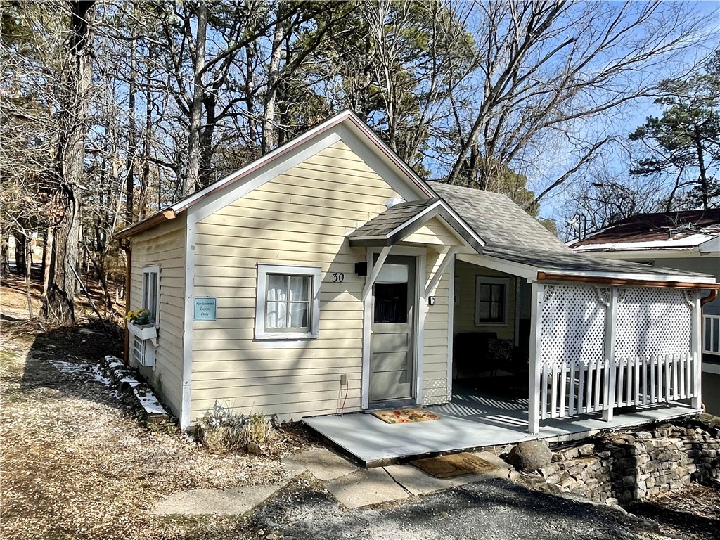 You'll enjoy this Eureka Springs getaway on the Upper Historic Loop that currently operates as a successful nightly tourist lodging. The historic cottage once served as a one-room schoolhouse and has all the charm you could imagine reflecting a relaxed cottage style. The covered porch is accessible from the kitchen making it a great place to entertain. The property is zoned commercial which allows for numerous uses. A great location close to downtown with off-street parking. Cottage style furnishings convey. Short jaunt to your favorite shops and restaurants and also on the trolley route. Short bike ride to Black Bass Lake trail system. Within a block of the Eureka Springs Community Center and Farmer's Market. Recently remodeled bathroom with a tiled shower. New roof in December 2024.