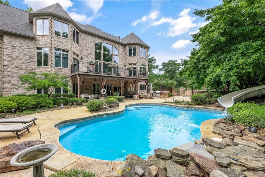 Step into the enchanting world of Maple Manor, where the a harmonious fusion of natural beauty & luxurious living. Nestled amidst sprawling woodlands, this estate offers a serene retreat-like privacy, where deer and other wildlife gracefully roam the surroundings. As you enter, the grandeur of the great room unfolds before you, a breathtaking vista of the woods through expansive windows. Immerse yourself in the custom kitchen, adorned with top-of-the-line amenities, perfect for culinary enthusiasts. Retreat to the lavish master suite, where a superbly appointed closet awaits, while an attached nursery offers convenience. A dedicated movie room beckons cinephiles to lose themselves in, while the multigenerational floorplan ensures ample space. Bask in the sun-drenched exterior entertainment area. Here, a heated gunite pool with a thrilling water slide awaits, accompanied by a fireplace and seating for unforgettable gatherings. Host guests in the separate guest apartment with its own private entrance.