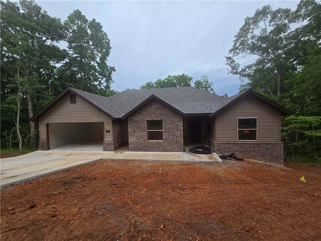 Discover this beautiful new home located in the desirable Highlands area of Bella Vista! This home features three bedrooms, each with walk-in closets, and two bathrooms. The spacious kitchen offers ample cabinet space and 3cm countertops, while the open dining area flows into a living room adorned with a vaulted ceiling. Additional highlights include energy-efficient LED lighting, Frigidaire stainless steel appliances, full aluminum guttering, and a large covered back deck that provides a peaceful view. Enjoy a quality home in a fantastic location, just a short drive from all that Bentonville has to offer!