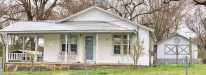 Charming country farmhouse located minutes from the Arkansas River situated on a well established 1 acre lot. Lush landscape & large shade trees add to the beauty this residence offers. Valuable outdoor space includes a front covered porch & rear sun deck. Spacious outbuilding & carports convey. 2 living areas (one w/ vaulted ceiling) or use one as a 3rd bedroom. Bright white kitchen cabinetry w/ partially open cupboards & appliances that convey. Add this delightful property to the must see list! $5,000 allowance for HVAC included.