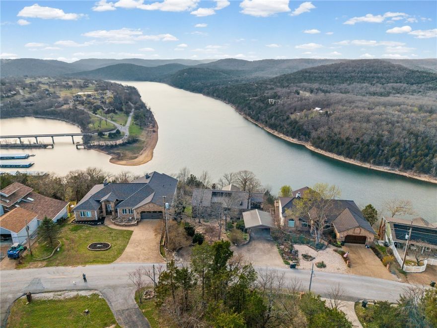 Location with Exceptional Views!!  Perched high above the main channel of Table Rock Lake, this Holiday Island retreat offers 180-degree lake views and a rare combination of privacy, accessibility, and lifestyle. Just 6 miles from Eureka Springs, 6 miles to Beaver Lake Dam, and only 31 miles to Branson, this location places you in the heart of the Ozarks’ most sought-after destinations.
The home features expansive outdoor living with a terraced backyard complete with a cascading waterfall, fire pit area, and irrigated front lawn. A private path leads down toward the lake, creating access to the water below.
Inside, the property is designed for flexibility and comfort with separate upstairs and downstairs living areas—ideal for hosting guests or multi-generational living. Fireplaces on both levels create warm, inviting spaces year-round. 
Enjoy seasonal views of the marina below and take advantage of discounted golf memberships. Add'l features include a security system with SimpliSafe for peace of mind.