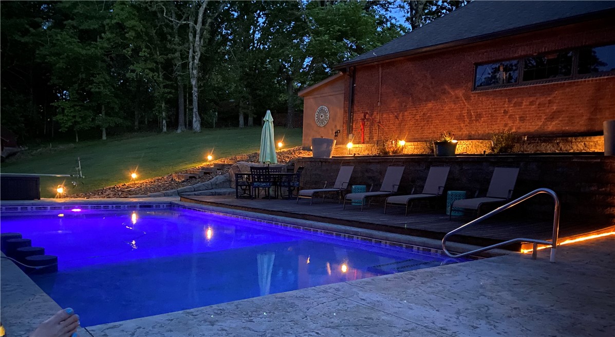 Beautiful, secluded, well maintained home in a quiet neighborhood just minutes to Beaver Lake. The large gourmet kitchens with tons of storage flows openly to the living room and has a formal dining room as well. The primary suite is situated on the main floor and shares a fireplace with a very spacious primary bath. The primary also has a large screened in private deck. On the lower level you will find 3 additional bedrooms, a second living area with a fireplace, game room and kitchenette/bar area. Walk out of the basement through another screened in porch area to the gorgeous inground heated pool with a swim up bar. This house is an entertainer's dream! The HOA does have a community boat dock on Beaver Lake. Winter views of Beaver Lake. Only 10 minutes to downtown Rogers, 25 minutes to Walmart Home office and a 45 minute drive to Eureka.