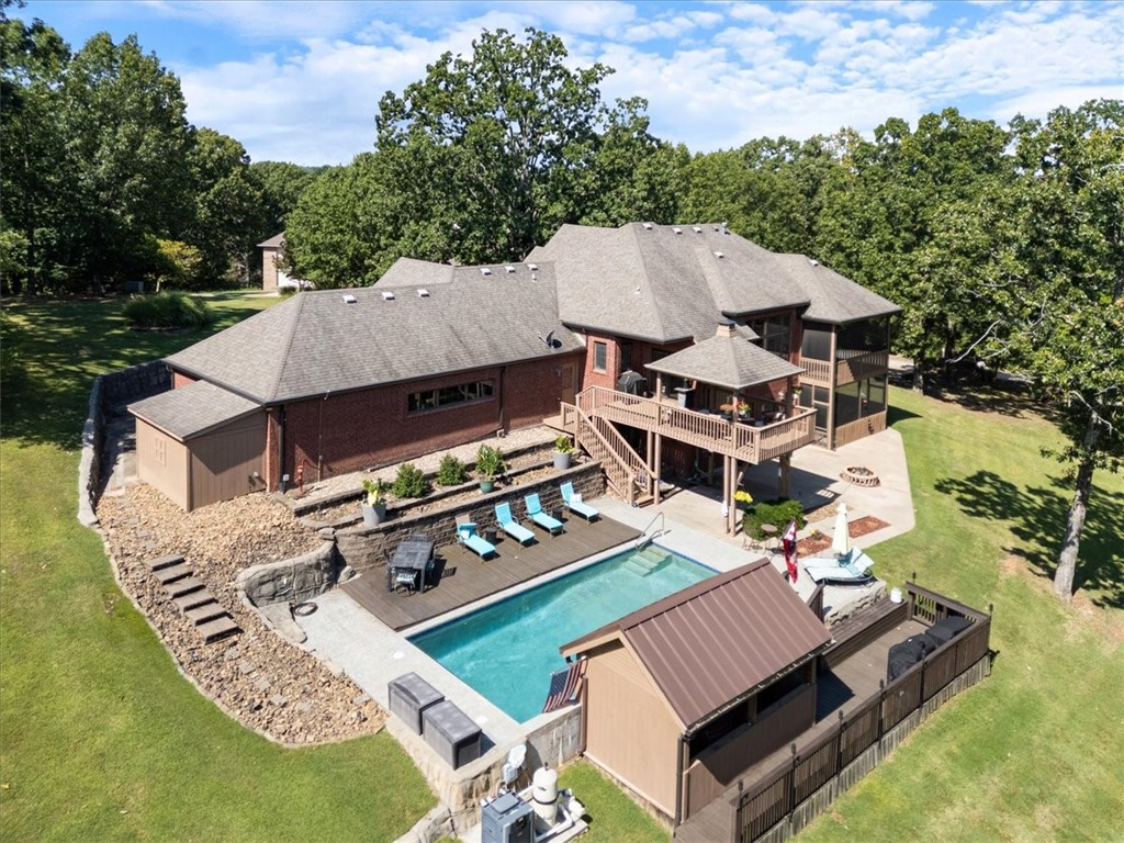 ~Motivated sellers~ Come check out this beautiful, secluded, well maintained home in a quiet neighborhood just minutes to Beaver Lake. The large gourmet kitchens with tons of storage flows openly to the living room and has a formal dining room as well. The primary suite is situated on the main floor and shares a fireplace with a spacious primary bath. The primary also has a large screened in private deck. On the lower level you will find 2 additional bedrooms, an office with a closet, a second living area with a fireplace, game room and kitchenette/bar area. Walk out of the basement to the gorgeous inground heated pool with a swim up bar. This house is an entertainer's dream! The HOA does have a community boat dock on Beaver Lake, that is available for owner and guest use. Winter views of Beaver Lake. Investors? This home can be used as a STR, however, no watercraft can be parked in the driveway or on the street. Only 10 minutes to downtown Rogers, 25 minutes to Walmart Home office and a 45 minute drive to Eureka.