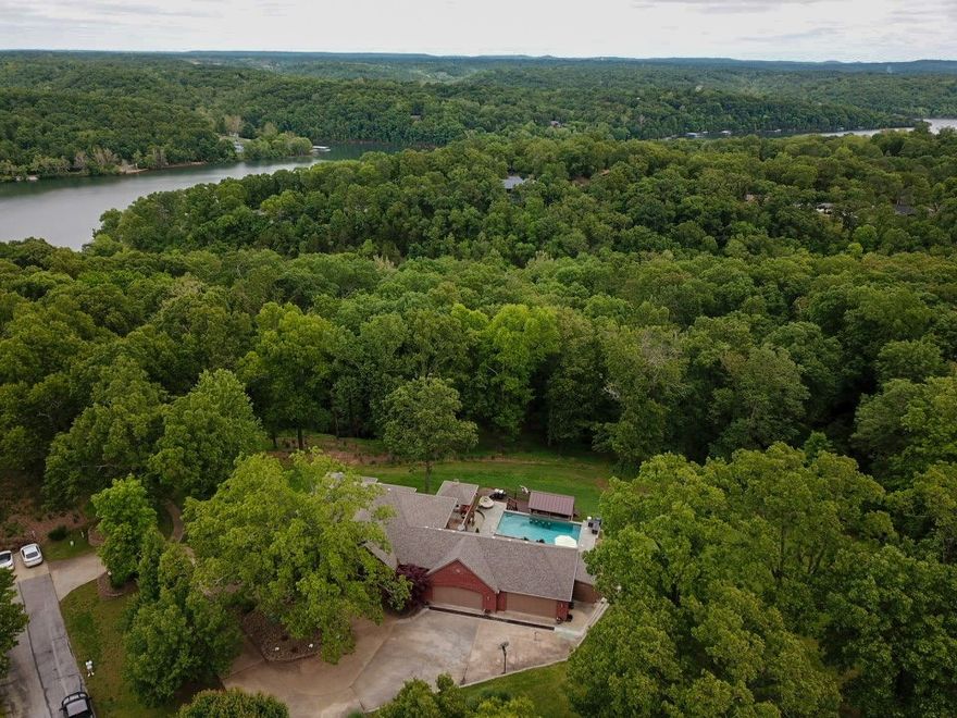 New paint in entry, dining room, downstairs and new carpet! Come check out this beautiful, secluded, well-maintained home in a quiet neighborhood just minutes to Beaver Lake. The large gourmet kitchens with tons of storage flows openly to the living room. The primary is situated on the main floor and shares a fireplace with the bath. Primary also has a large screened in private deck. On the lower level you will find 2 additional bedrooms, an office with a closet, a second living area with a fireplace, game room and kitchenette/bar area. Walk out of the basement to the gorgeous inground heated pool with a swim up bar. This house is an entertainer's dream! The HOA does have a community boat dock on Beaver Lake, that is available for owner and guest use. Investors? This home can be used as a STR, however, no watercraft can be parked in the driveway or on the street. The home does not include a boat slip but you can use the community docks for fishing and swimming.
