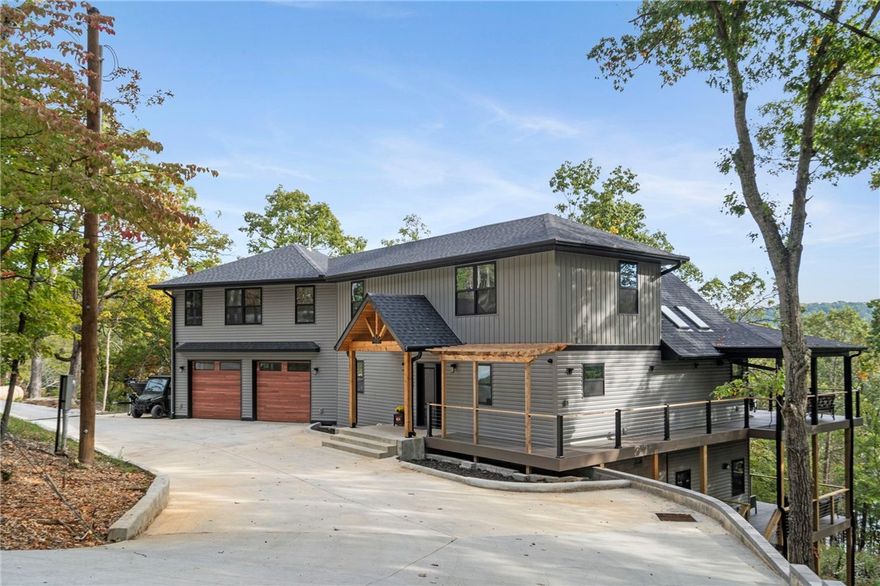 Experience the perfect balance of modern comfort & lakeside living in this brand new, custom home, ideally positioned to capture water views & easy access to the lake. Just steps away from your boat slip, this property offers the quintessential lake lifestyle...boating, fishing, swimming or simply soaking in the serenity of nature. Step inside to discover an open concept floor plan, plenty of natural light & a gorgeous kitchen w/quartz counters, custom cabinetry, plus walk-in pantry! There's a main level mud room off the 2-car attached garage as well as a separate laundry room. Upstairs you'll find the primary suite w/double sleeping rooms. The bath offers spa-inspired finishes w/soaking tub, walk-in shower & double sinks. Enjoy morning coffee or evening cocktails on the covered decks amidst the tranquil, wooded setting. Located off Beaver Lake's desirable Indian Creek, this Garfield home is ideal for full time residence, a weekend getaway, or an investment property!  (25 min. to Rogers & 40 min. to Eureka Springs)
