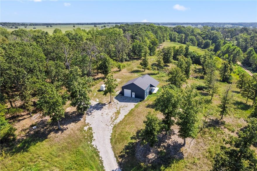 Welcome to "Leaning Tree" – a unique family compound. Custom-built 2-bedroom, 1.5-bath home nestled on 5 serene acres. The property features an 800 sq. ft. shop with an extra-large insulated garage door, perfect for your projects or storage needs. The home boasts elegant granite countertops, custom cabinets, and premium LG appliances, complemented by an expansive front porch for relaxation. Additional highlights include a well-insulated well house, mature trees, and abundant wildlife. A completed perc test and installed septic system support a 5-bedroom capacity, providing the option to build a 3-bedroom home on the cleared building site. This is your private haven, blending comfort with potential. Don’t miss out on this exceptional property!