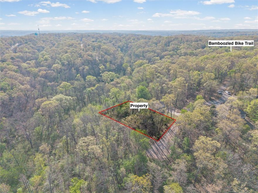 Tucked away on a private cul-de-sac off Nottingham Dr, this desirable 1/3-acre lot offers the perfect blend of privacy and accessibility. Partially wooded for a serene, natural setting, with the Bamboozled trail crossing right at the street—ideal for outdoor enthusiasts. Enjoy close proximity to Bella Vista’s premier amenities including Loch Lomond, Lake Avalon, and Lake Windsor, as well as Tanyard Creek Park, Sugar Creek, Kingsdale Golf Course, Swimming Pool + Recreation Area. Plus, you’re not far from the OZ Trails Bike Park, set to open June 12th. With trails galore and endless recreation nearby, this is an ideal setting to build your dream home. Perc test available.