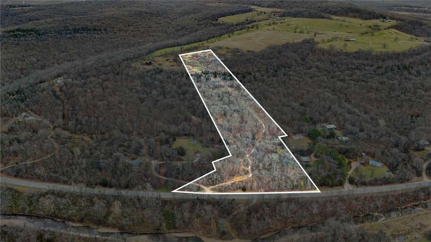 An exceptional 11.33 acre tract on Delgado Road in West Fork, offering privacy, scale, and immediate access to Highway 71. The location is supreme, providing an ideal setting for a private estate, multi-generational family living, or strategic land hold. Located near the White River and just 15 minutes from the University of Arkansas, this property combines a peaceful, secluded feel with proximity to Fayetteville and the growing NWA corridor. The neighboring parcel is also available, presenting a rare opportunity to assemble significant contiguous acreage for estate-scale use or future development.**The drone photos are not surveys and lot lines are estimated in them. PDF of legal survey available.