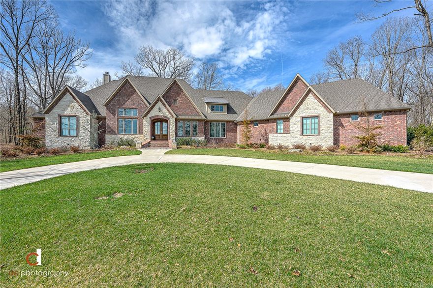 Stunning Home in East Fayetteville on over 8 Acres! Just 25 minutes to Downtown Fayetteville, enjoy secluded living in nature with all the beautiful views that Goshen has to offer. Breathtaking features of this home will greet you as you arrive, including the 18' cathedral ceilings. Immaculate and better than new, no detail has been missed. From oversized walk-in closets, to carefully designed storage and pantries, this home is as custom as it gets! The master suite is incomparable with a brick accent wall, remote window shades, a luxury bathroom, dreamy closet, and exercise room to accommodate every need... and the closet connects to the spacious laundry room with a built in dog kennel. The cedar wrapped screened in porch boasts a 22' vaulted ceiling for year-round relaxation and nature viewing. Epoxy garage flooring, professional landscaping & sprinkler system. Too many details to list- MUST SEE!  Bonus: Ozarks go internet allows for a carefree work from home environment in a grand office with 14' ceilings.