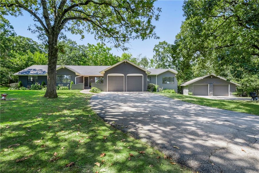 Centrally positioned along the Razorback Greenway trail in Fayetteville and across the street from Gulley Park, a fully updated, one-level home sits on just shy of an acre at 2433 N Old Wire Road. Imagine living ten feet from the acclaimed Greenway trail. During the summer on Thursday nights, you grab a cooler of snacks and a blanket to sit on before walking five minutes down the paved bike trail to the Gulley Park Concert Series. Year-round, you and yours enjoy the beloved park’s trails, pavilions, exercise equipment, and coming soon – new playground and splash pad. For more private gatherings, host at home, beneath the massive old oak trees or on your 720 SF custom-built deck. And for going out, the 4.5 minute drive to I-49 makes it a breeze to access to all NWA has to offer. Fully updated & all on one level, this 4 bed, 3.5 bath, home has 2 living rooms, a chef's kitchen, indoor and outdoor fireplaces, 2-car attached and 2-car detached garages, and more. Inquire about purchasing this home fully furnished.