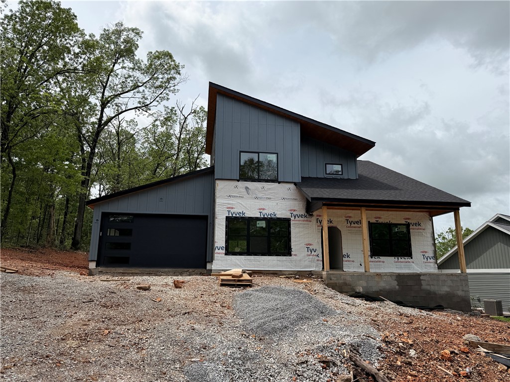 Discover this exquisite new construction in Bella Vista featuring full POA amenities! The modern yet minimalist design showcases white oak cabinets, matte black fixtures and hardware, and quartz countertops throughout. Enjoy two spacious bedrooms with huge walk-in closets, a dedicated office, and 2.5 stylish baths. The versatile floor plan offers two living areas. The main floor is anchored by an electric fireplace with custom built-ins, while the kitchen's massive island creates a perfect gathering space. Indoor-outdoor living comes easy with both an upstairs balcony and main floor deck, and the timeless exterior combines brick with concrete batten board siding. This thoughtfully designed home balances contemporary style with natural elements, creating an inviting space that's both sophisticated and comfortable - all just steps to Bella Vista's incredible trail systems with easy access to Bella Vista's complete range of amenities.
