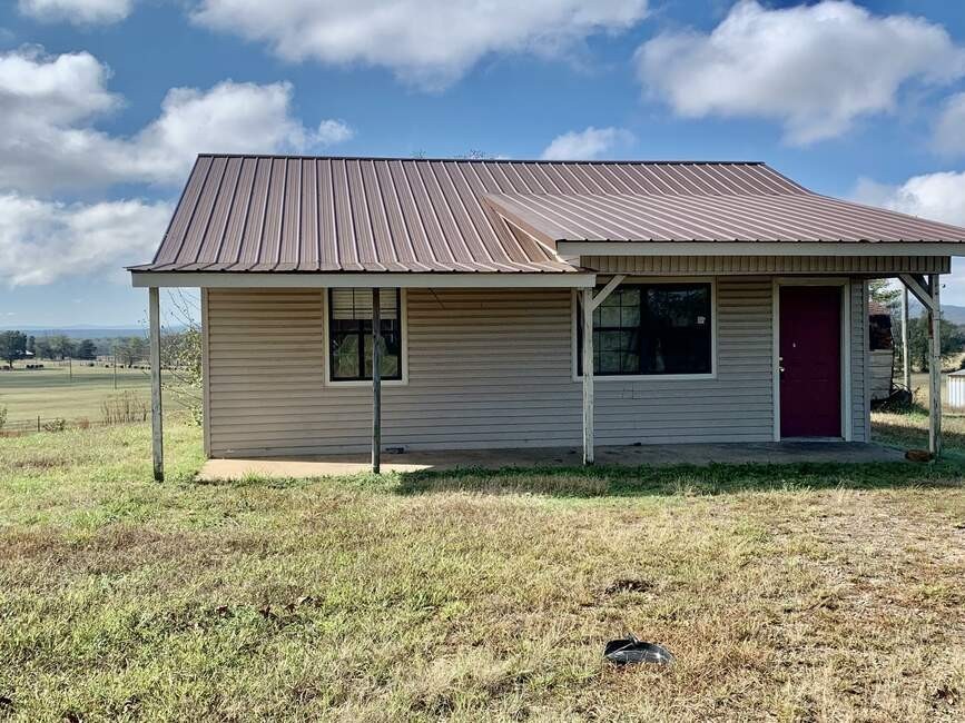 This Beautiful property is perfectly situated on a serene 20.06 acres, just minutes from downtown Waldron. This lovely property comes with a one bedroom, one bathroom cabin/home, and a 1600 square foot home that has been framed with metal roof, concrete slab, and ruff in on plumbing, and in the dry with house wrap and windows. ready for someone to complete and reap the rewards. This amazing property comes with a view of the mountains and a large pond. This lovely property with two homes offers an ideal blend of modern living and countryside charm, with ample space for the entire family and guest both inside and out. Several options on pastures all fenced, with a shop/tool equipment shed and a storage building.