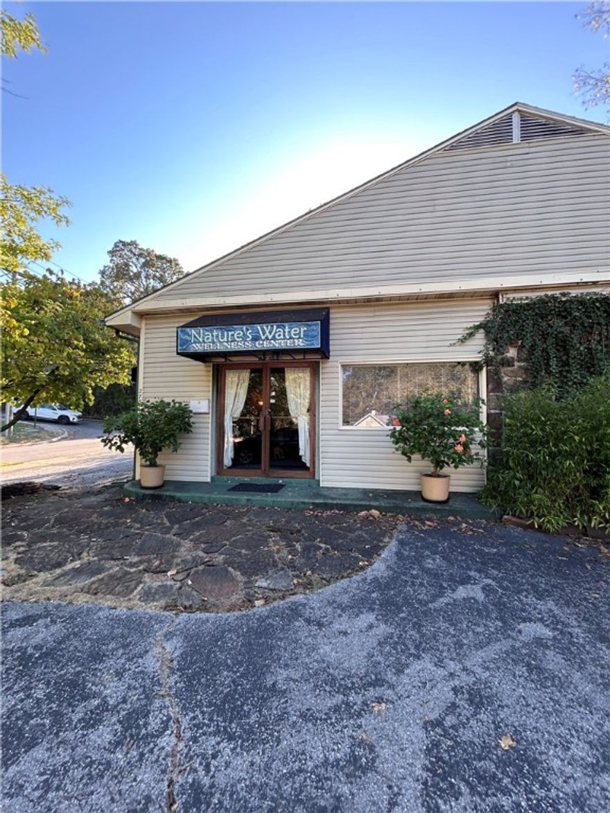 Excellent downtown area property that historically has had 'wellness' related businesses.  A rare offering only 3 blocks from the square in Fayetteville. The building currently houses various therapists (all leases have expired).  With established and matured neighborhood, this building would work well for a day spa, office building, sales offices, neighborhood convenience store, bicycle shop, medical or dental office, animal clinic or office rentals.  The common areas include a large entry, reception room, plus a very large center space where a kitchenette occupies one wall.  Two common half baths are accessible to all, and a 3rd half bath is within one office space.  A basement below most of the space can be used for storage and provides good access for adding or reworking plumbing, electrical, and other systems. The locals know this building as Nature's Water Wellness Center. Owners enjoyed many years using it as a water filtration business location.   Latest County Valuation is $870K.  Sold "AS IS"