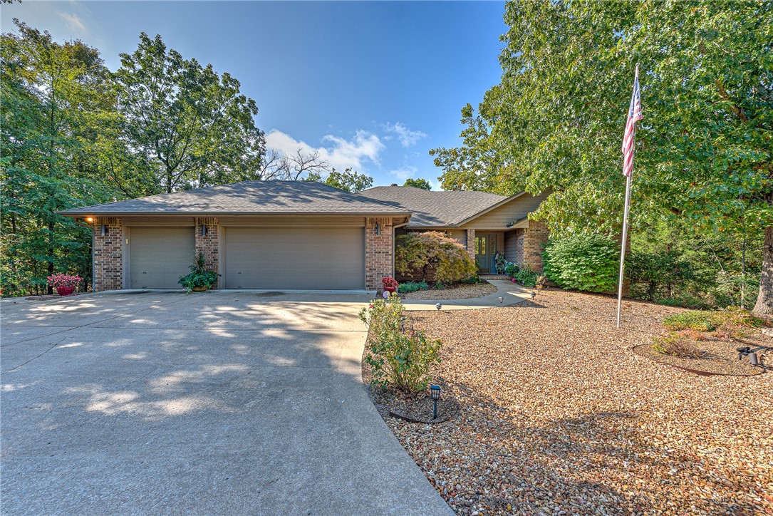 Well kept OAK Home with geothermal heat and air. Beautiful landscaped low-maintenance rock yard. Added 225' Sunroom off of the living/kitchen for a total of 2036 sqft. The 24x15' living room has a wood burning fireplace and sets the tone for the comfort of this split floor plan house. The cozy sunroom leads out to the deck and down to the 520 sqft shop (not included in the total sqft) as well as the crawlspace that houses the air handler and water heater. The beautiful rock yard has a sidewalk that takes you to the front of the house and 3 car garage. This home is close to The Highlands Golf and Pub, Branchwood Rec Center, Loch Lomond Lake, The Highland Gun Range with easy access to I-49. Come see all that Bella Vista has to offer, including the best mountain bike trails, ever.