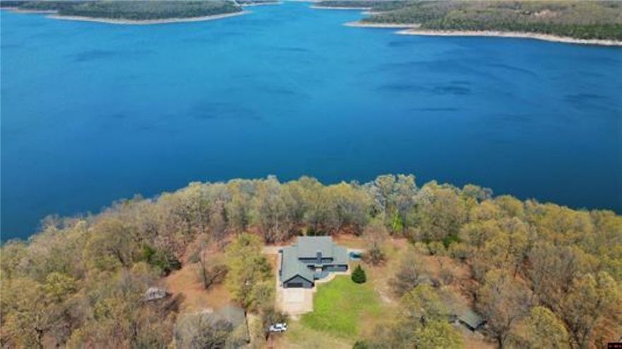 Looking for your own slice of heaven? Welcome to this stunning lakeside estate on 3 AC M/L with end-of-the-road privacy and incredible access to Bull Shoals Lake! This one-of-a-kind 4-bedroom, 4-bath beauty offers over 5,000 sq ft of comfortable, spacious living—perfect for hosting, relaxing, or just soaking in the good life. Step inside and head down to the basement, where you'll find a custom-built bar and a huge open area—ideal for a game room, man cave, or the ultimate kids' hangout. Whether it’s movie nights, ping pong tournaments, or weekend parties, this space is designed for fun and entertaining on a grand scale. Step outside and fall in love with the outdoor kitchen, gazebo, covered front porch, and breezeway connecting to a massive 32’ x 40’ covered patio/carport—perfect for lakeside gatherings, summer cookouts, or simply unwinding under the stars. Plus, there’s a 24’ x 40’ detached garage with room for your boat, workshop, or weekend toys.