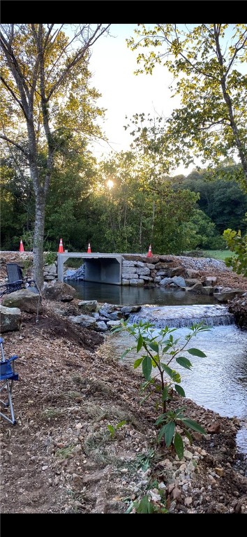 Looking to build a custom home on acreage with utilities and protective covenants? Offered for sale is one of three parcels in a planned gated community. Includes 160 sf tiny home, ready for drywall, and a 2022 2bed 2bath 43' Saber fifth wheel travel trailer. Long private drive across picturesque Challabeate Creek and up the hill to a secluded, secure 3.6 acre parcel with several potential homesites. This area is teeming with wildlife and natural flora and fauna. Located in the NW corner of Benton County, Arkansas, 35 minutes to Crystal Bridges American Art Museum, Bentonville downtown, the new Walmart HQ, world class bike trails. 10 minutes to Harps Grocery Store in Gravette Arkansas, 19 miles to a Walmart supercenter in Jane, MO. Water is a shared well, Carol Electric, 4 bedroom septic. Live in the RV and tiny home while building the house.