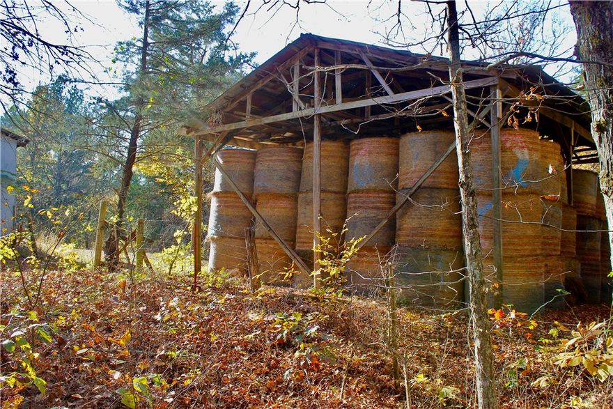 This 10+/- acre tract offers a blend of useful infrastructure, natural beauty, and expansion potential. The property has a water well, electric, propane line, and a possible septic system from a former homesite. A well house is in place, and internet is available, making this an ideal location for work or comfortable country living. Two large barns, one measuring approximately 44'x50' and the other 32'x50', provide ample space for storage, equipment, hay, or livestock. The acreage includes hardwood timber, rock bluffs, and a spring tucked into the hillside. These natural features offer incredible opportunities for hiking, hunting, or simply enjoying the environment. The terrain is varied yet accessible, with multiple potential build sites that offer privacy and views of the surrounding countryside. Located just 2 +/- miles off a paved Highway 23 and near a local swimming hole on War Eagle Creek. It's about 22 minutes to Huntsville, Arkansas, for supplies and conveniences, and just an hour’s drive to Fayetteville