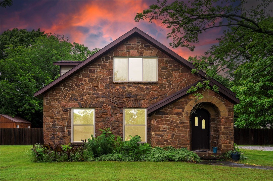 Charming and fully renovated 1930s stone home on an oversized lot just minutes from Prairie Grove Battlefield Park! This 3 bed, 2 bath home offers 2,326 sqft, a bonus room, and endless storage. Enjoy high ceilings, stone accents, engineered wood floors, updated lighting, granite countertops, and a bright kitchen with coffee bar and all new appliances. Spacious baths feature walk-in glass showers and double vanities. Renovated in 2018 with new windows, roof, plumbing, and electrical. Brick patio and mature landscaping complete this historic gem!