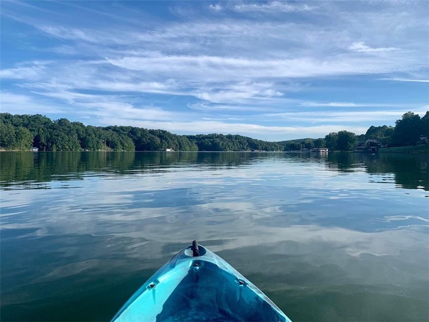LAKEFRONT! Beautifully updated home on Lake Windsor. Gorgeous views from every room! Enjoy skiing, fishing, swimming, kayaking, etc. and be less than 20 minutes to downtown Bentonville.  Over 150' of leveled shoreline with a new seawall and composite dock. Boat house has new roof and hardy board siding; covered boat slip w/lift for safely storing your boat year-round.  Concrete path to lake for walking or cart. Walkout basement, oversized H/C garage, H/C sunroom, wrap around upper deck, private master deck, covered downstairs patio, stone firepit. New maintenance free chocolate rock landscaping. Recent upgrades include HVAC system, roof, hardy board siding with stone accents; facia, gutters, downlighting; maintenance free composite decks with aluminum railing; granite kitchen counters, propane gas cooktop, stainless appliances, textured tile and luxury carpet; custom iron stair railings, stone fireplace with gas logs; lights, ceiling fans, paint and more! Truly beautiful place to call home.
