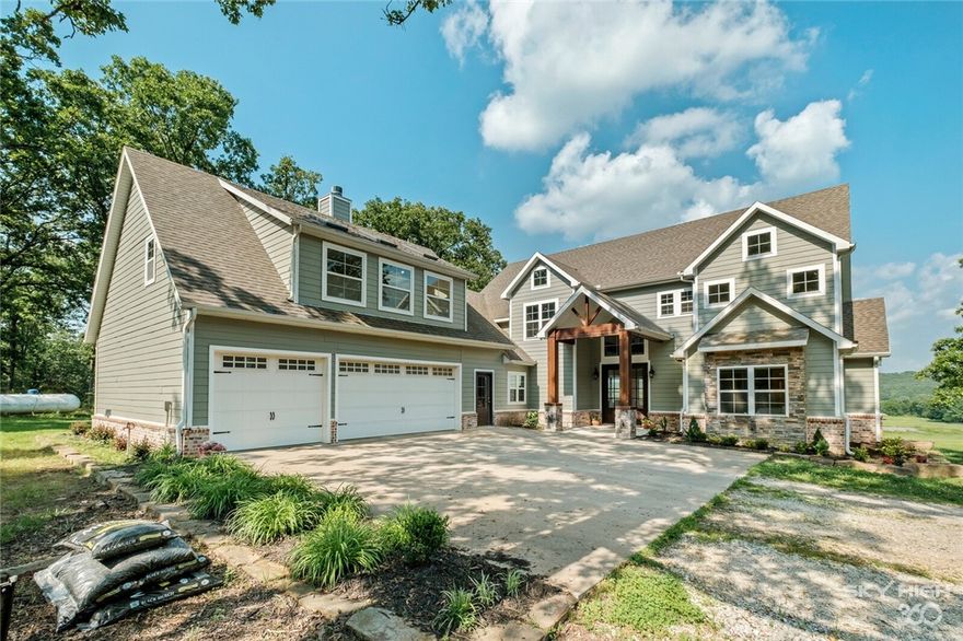 Stunning and secluded home on approximately 20 acres just East of Fayetteville.  Home boasts a magnificent open living/kitchen/dining area.  Wonderful views to the East.  Spacious master suite, huge laundry/mudroom, tons of storage.  There's a complete in-law suite above the garage.  Full kitchen, LR, 2 bedrooms and 2 baths.  Wonderful covered back patio.  50x50x18 insulated shop building with two o/h doors.  See virtual tour for many more pictures.