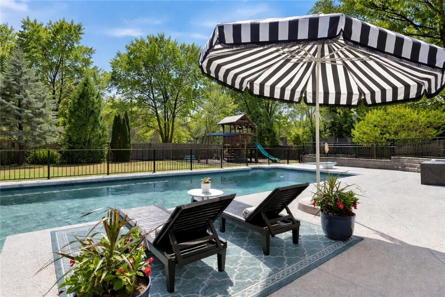 Your private LUXURY retreat awaits with this stunning home designed for both everyday living & effortless entertaining. Step inside to an open, beautifully flowing floorplan with rich hardwood floors, custom shades & abundant natural light filling the main living spaces. The living room features vaulted, beamed ceilings & a cozy gas fireplace. The open concept kitchen is thoughtfully designed w/ stainless steel appliances, double ovens, large island & formal dining. Off the kitchen, with a separate entrance from the pool area, the wet-bar area enhances entertaining with sink, ice maker, wine & beverage fridge. The main level includes all 4 bedrooms & a dedicated office, including a spacious primary suite w/ patio access, spa-like bath w/ jacuzzi tub & large walk-in closet. Upstairs is a bonus room that can flex as a 5th bed/rm! Outside, enjoy the gunite saltwater pool, patio w/ fireplace & privacy fence. More features: Ecobee thermostats, new roof 2024 and cigar vent in the sports bar room! Central Vac & near I-49