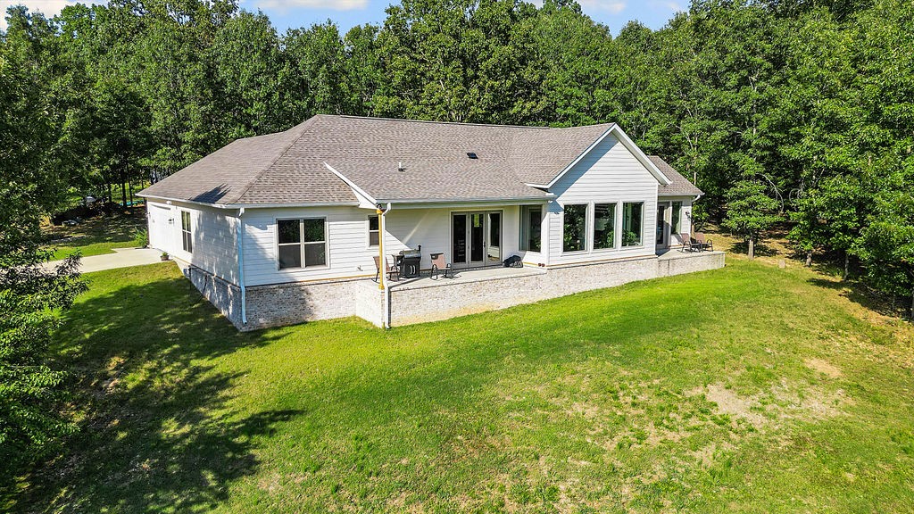 Set on 5 acres, this 1-story 2022 build blends everyday comfort w/ sophisticated design. Featuring 3 beds, 2.5 baths & an office, the thoughtful split floor plan balances open-concept living w/ privacy, while an oversized entryway welcomes you into the sun-filled living spaces. Large windows throughout flood the home w/ natural light, accentuating the modern finishes. At the heart of the home is the kitchen, complete w/ a 10ā island w/ bar seating, walk-in pantry, SS appliances & a 6-burner gas cooktop. A dry bar enhances the dining area, while french doors open to a covered patio, perfect for entertaining. The living room features vaulted ceilings, a gas fireplace & a custom oak mantle. The primary suite is a true retreat w/ a private patio. The ensuite bath features a soaking tub, walk-in shower, dual vanity, & generous walk-in closet. With private lake access & a sandbar, 2 patios for year-round enjoyment of breathtaking views, this home perfectly blends luxury and functionality in a serene lakeside setting.