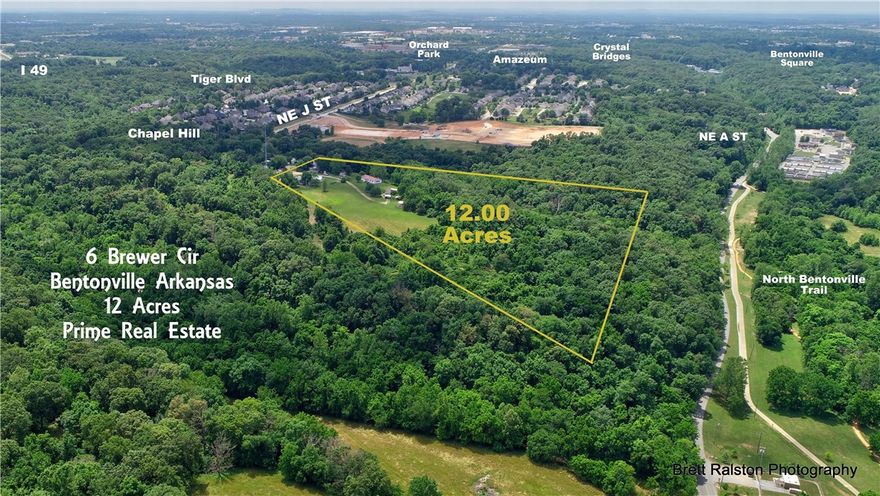 Location! Location! Location! Great investment/development potential, conveniently located on the very desirable NE side of Bentonville. Easy access to the Slaughterpen biking and trail system and I49, shopping and Crystal Bridges. Property is partially cleared for building sites, has beautiful hardwood trees and minimal restrictions.  Modular home, single wide, shop next to single wide and 3 carports now located on property, do not convey and to be moved after close of sale.  Other outbuildings on property convey but are of no value.