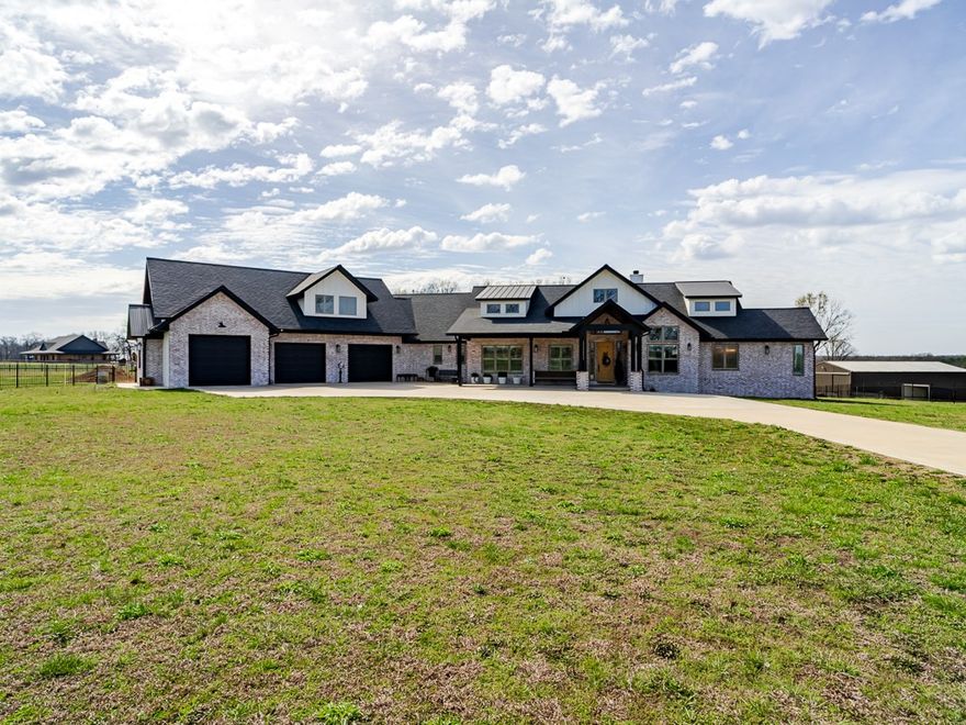 Lovely New home completed  in 2024 situated on 5 level acres, 3 BR, office, two bonus rooms, huge family room/dining/kitchen combo, plantation shutters, Quarts counters throughout, new brushed gold sink and hardware, main bedroom with sunroom, gorgeous bath w free standing tub, extra lg shower, huge walk-in closet, including large metal shop building 220 wiring, opens front and back, 2 overhead doors, walk door, roof insulated 2 livestock sheds, concrete driveway, iron fencing, 3-4 car garage, wired for generator, covered porches and deck! septic and propane. Mini horses and mini donkeys in pasture, keep gates closed. Approx 10 beautiful adjoining acres with pond and fencing can be purchased for $750K Approx 2 blocks off highway 102 on gravel road, have been told the county plans to blacktop 2027. Seller cannot close on sale until May 29th, 2026, Near proposed new highway development. No showings on Sundays. Seller/owner is a licensed real estate broker currently active in NWAR. Call 479-936-4707 to show.