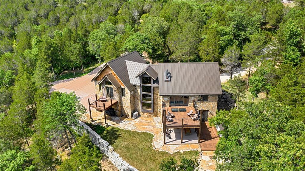 Breathtaking custom-built home with guest house & workshop situated on 6+ gorgeous secluded lakefront acres makes this a must see! Enjoy the lake/wet weather creek/waterfall from one of your private decks/covered patio/firepit or walk down to waters edge. Both homes built with ICF energy efficient construction. Main home includes wood beams, vaulted ceilings, floating ironwork stairs, wood/stained concrete floors and much more. Master with private deck, walk in closet and huge shower with heated floors. Open floorplan includes great room (opening to spacious deck)/wood stove/dining area/kitchen with granite countertops, large island, custom cherry cabinets, and commercial grade Monogram appliances. Lower level includes 2 bedrooms, family room with wood stove and provides access to 2 car garage or walkout to covered patio and fabulous outdoor kitchen. Guest house includes large workshop with wood stove and 1 bedroom/1 bath. Sale includes a 12'x28' boat slip located nearby. See attachments for additional details.